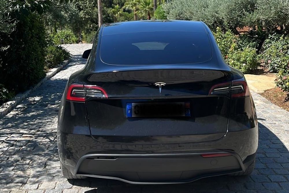 Black business-class car parked on a cobbled drive